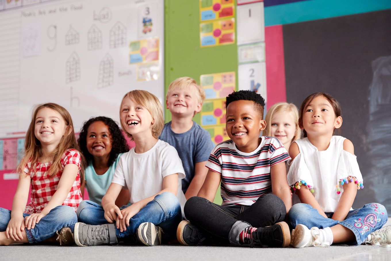 Group Of Elementary School Pupils Sitting On Floor In Classroom Group Of Elementary School Pupils Sitting On Floor In Classroom