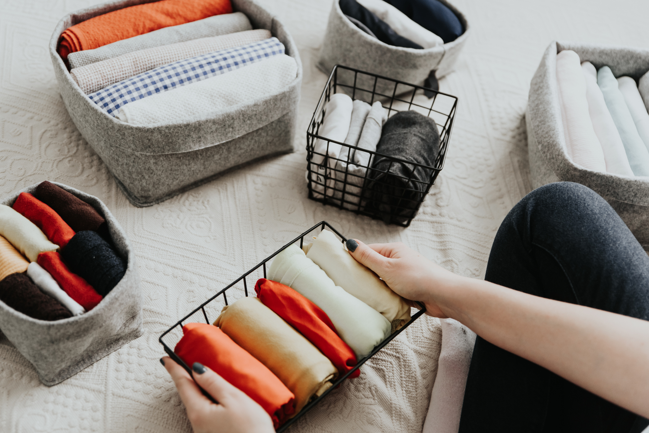 Folding clothes and organizing stuff in boxes and baskets. Concept of tidiness, minimalist lifestyle and japanese t-shirt folding system. Folding clothes and organizing stuff in boxes and baskets. Concept of tidiness, minimalist lifestyle and japanese t-shirt folding system.