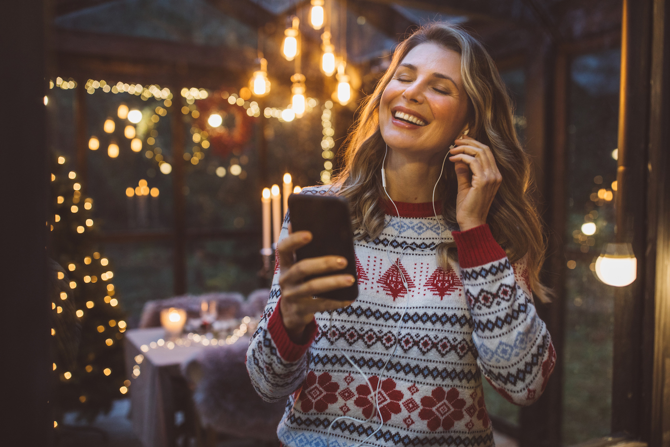 Woman in a sweater listening to music Woman in a sweater listening to music