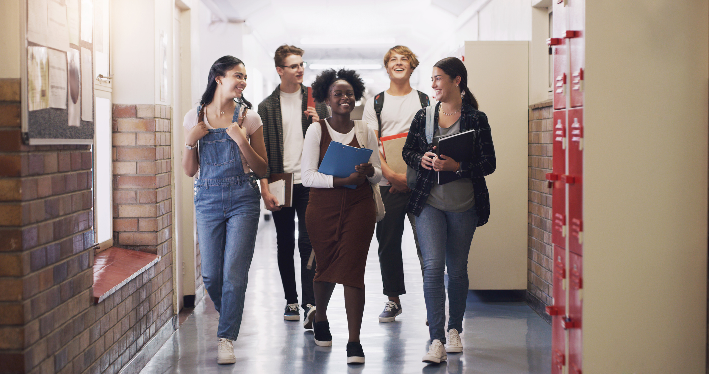 Shot of a group of teenagers walking down the hall at high school Shot of a group of teenagers walking down the hall at high school