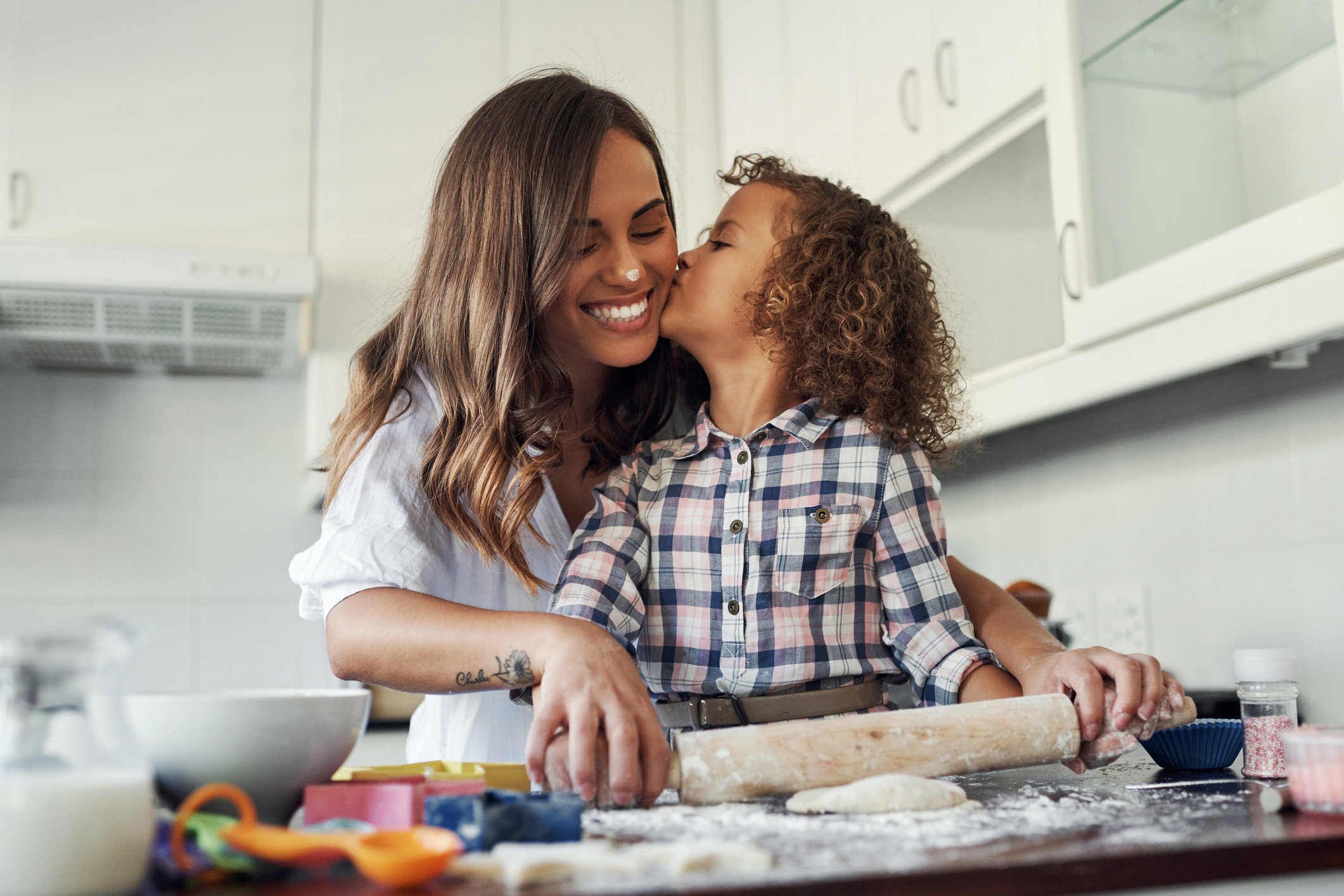Shot of an adorable little girl being affectionate while baking with her mom at home Shot of an adorable little girl being affectionate while baking with her mom at home