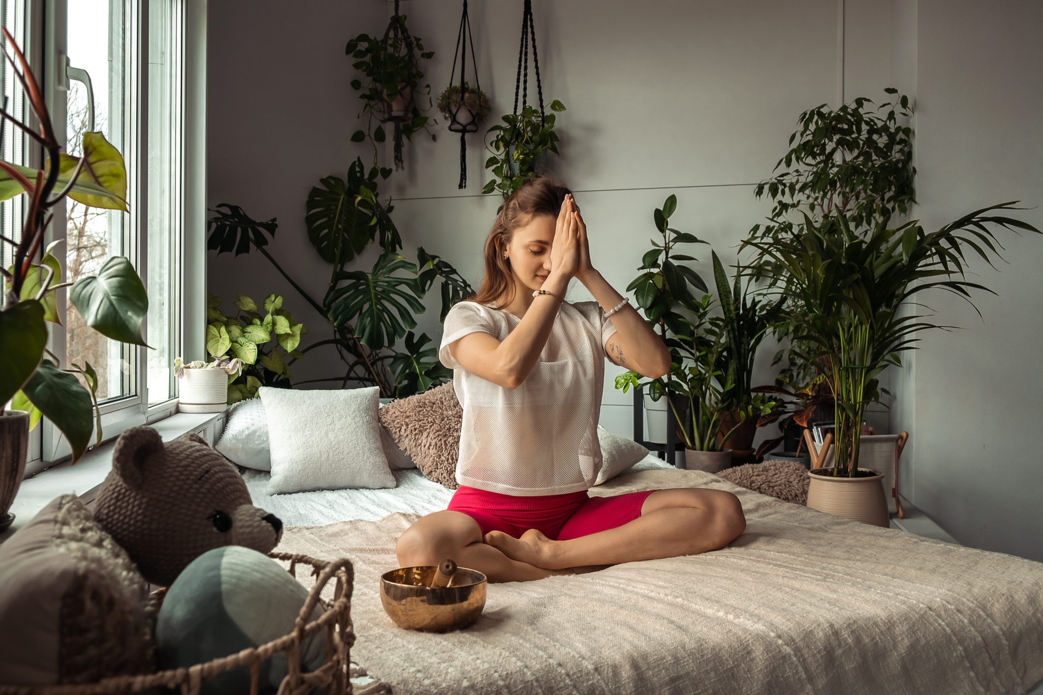 Young sporty woman practicing yoga at home,sitting in Lotus position,namaste hands.Relaxation and meditation.Wellness,wellbeing,mental health concept Young sporty woman practicing yoga at home,sitting in Lotus position,namaste hands.Relaxation and meditation.Wellness,wellbeing,mental health concept
