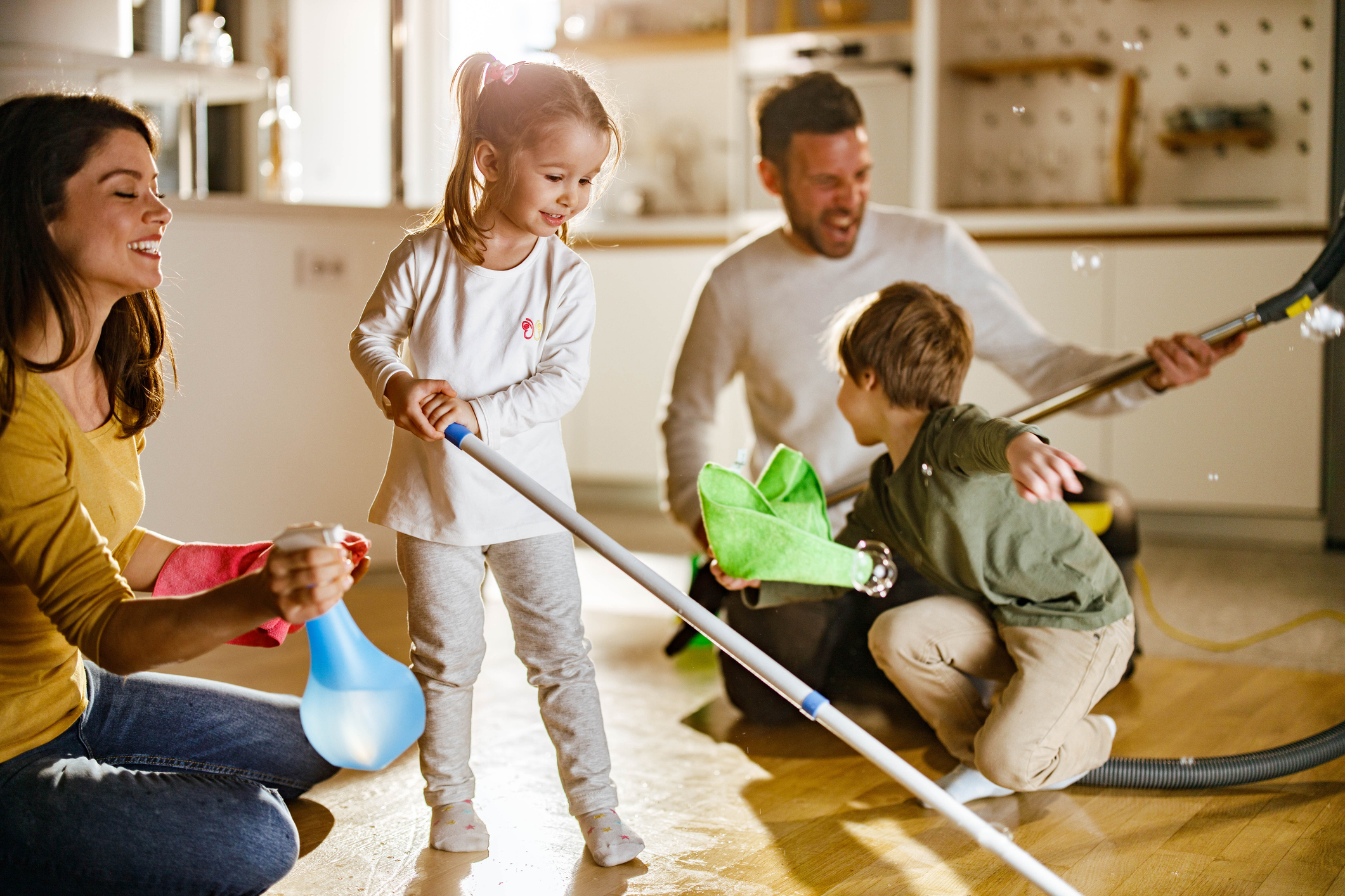 Happy family having fun while doing chores around the house. Happy family having fun while doing chores around the house.