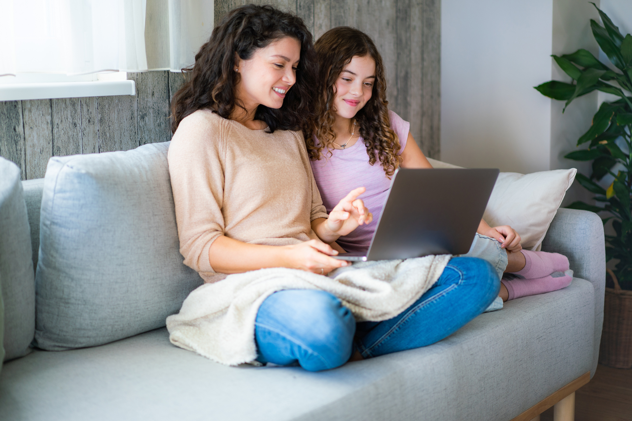 Mother and daughter using a laptop together at home Mother and daughter using a laptop together at home