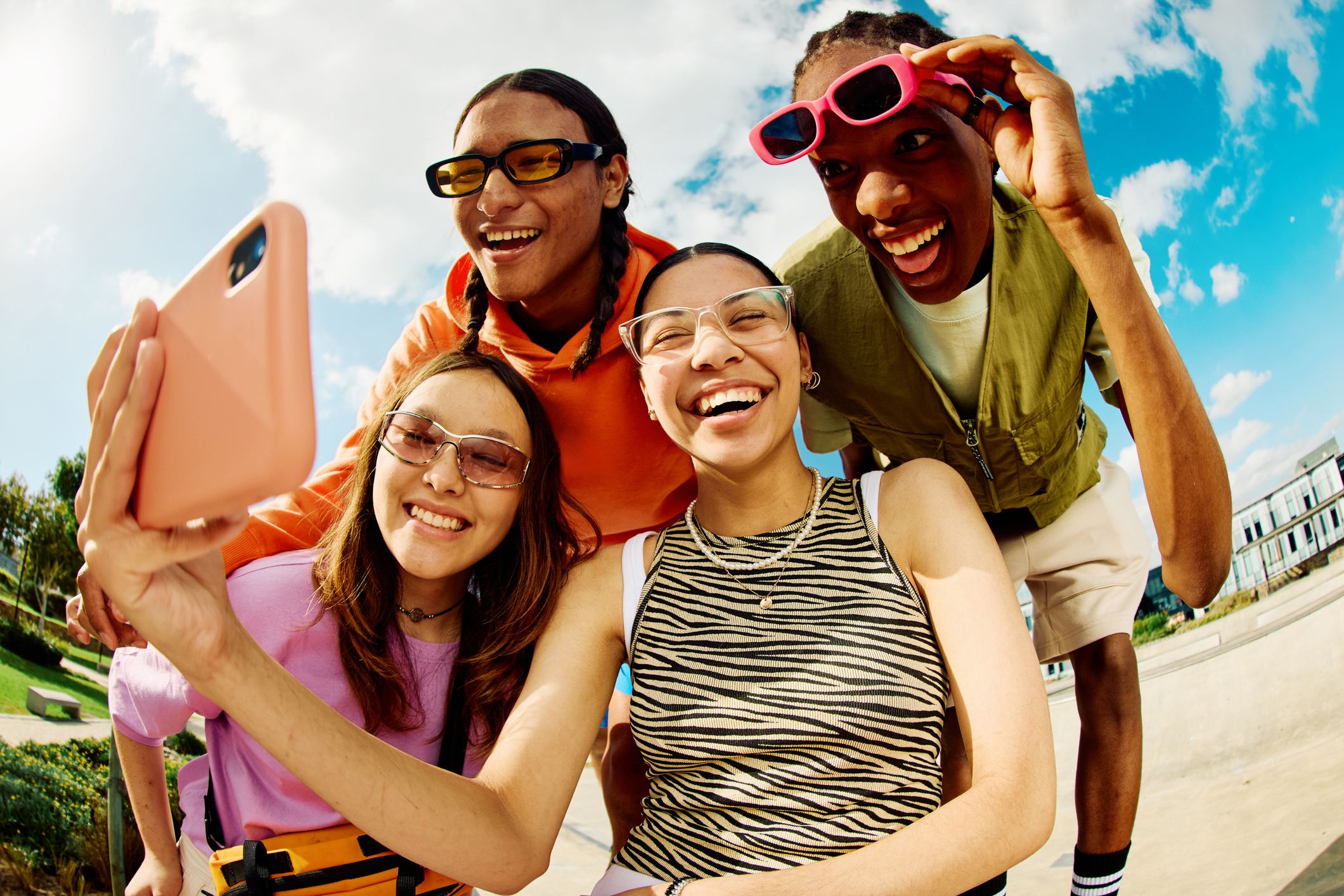 Wide angle shot of Gen Z group of friends using a smartphone together. Wide angle shot of Gen Z group of friends using a smartphone together.