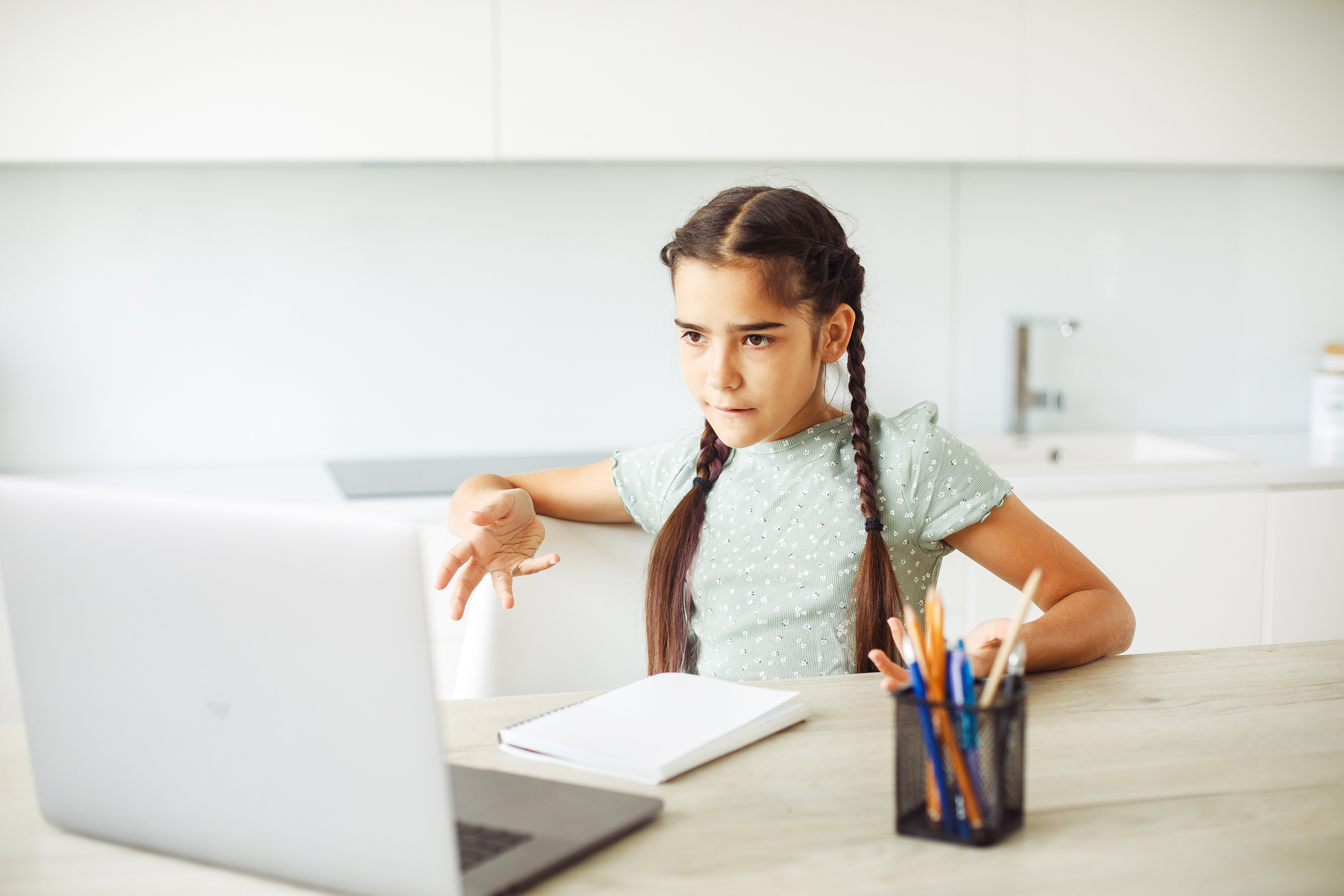 Schoolgirl sitting at home at laptop and doing homework Schoolgirl sitting at home at laptop and doing homework