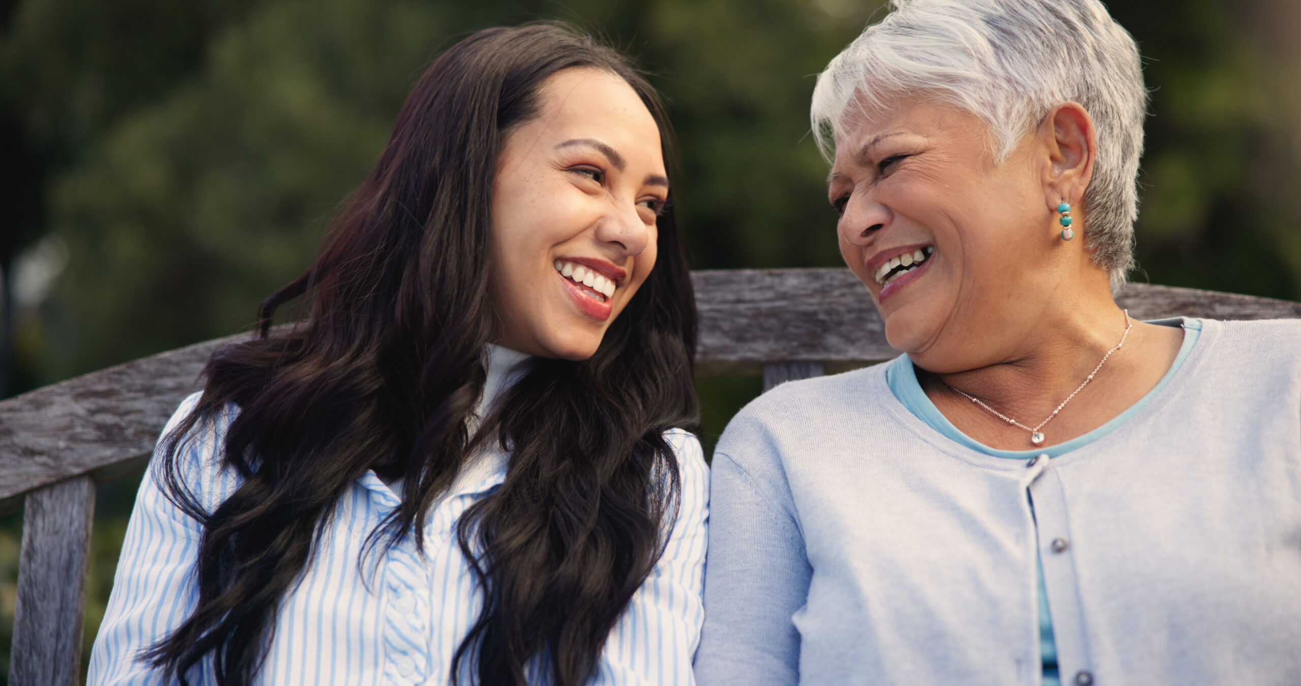 Happy, mature and mother with woman on bench, nature and bonding for laugh on retirement. Senior person, parent and older daughter for leisure together in park, care and love for funny joke in garden Happy, mature and mother with woman on bench, nature and bonding for laugh on retirement. Senior person, parent and older daughter for leisure together in park, care and love for funny joke in garden