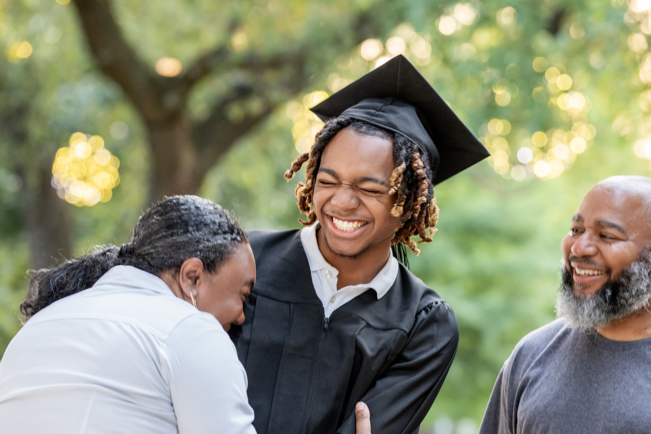 A mother and her son share a smile and a laugh as they prepare for his graduation ceremony. A mother and her son share a smile and a laugh as they prepare for his graduation ceremony.