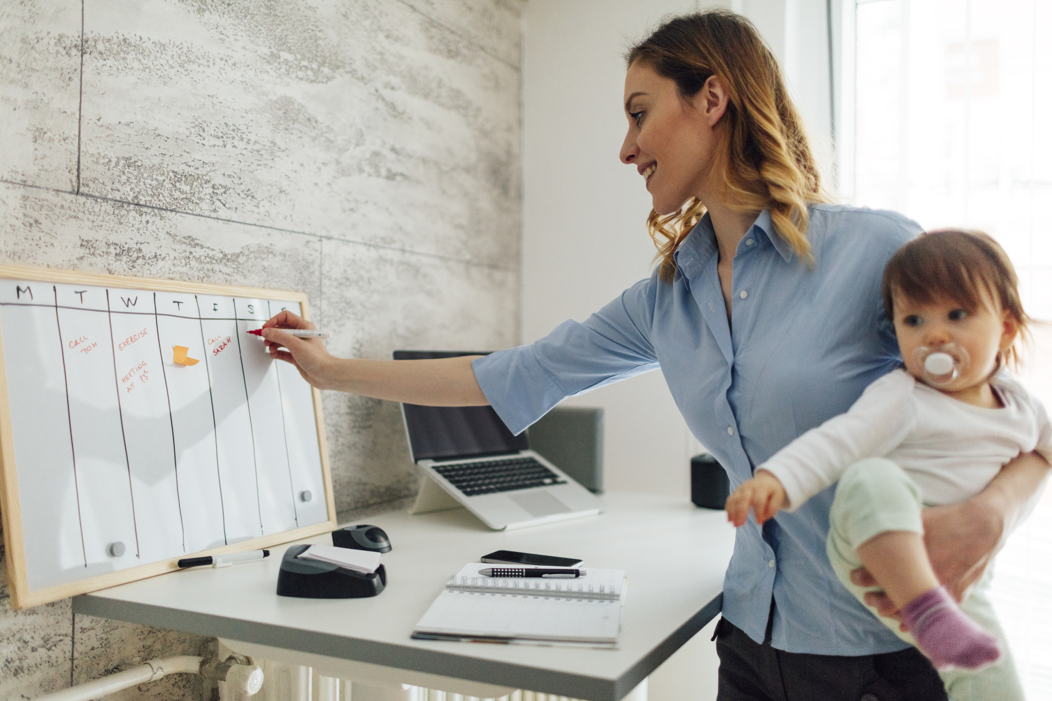 Mother Working From Home And Holding Her Baby Mother Working From Home And Holding Her Baby