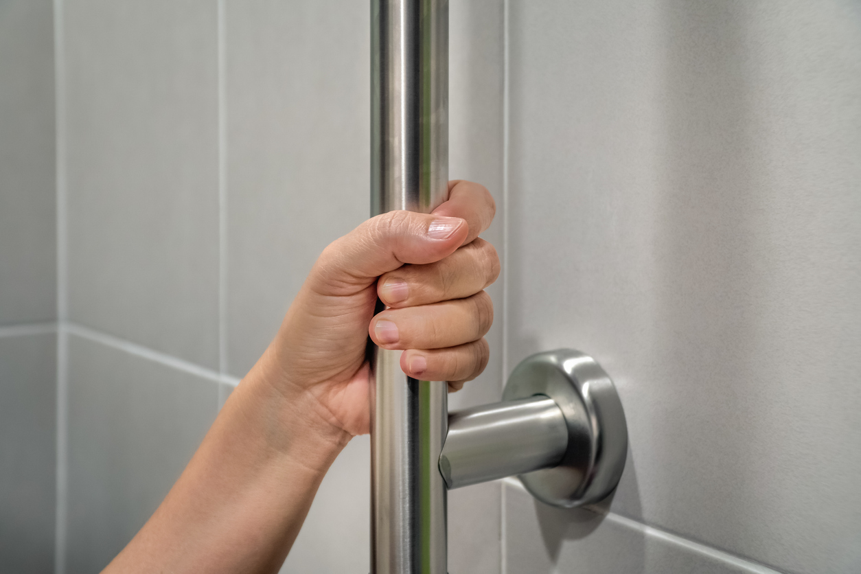 Woman holding on handrail in toilet. Woman holding on handrail in toilet.