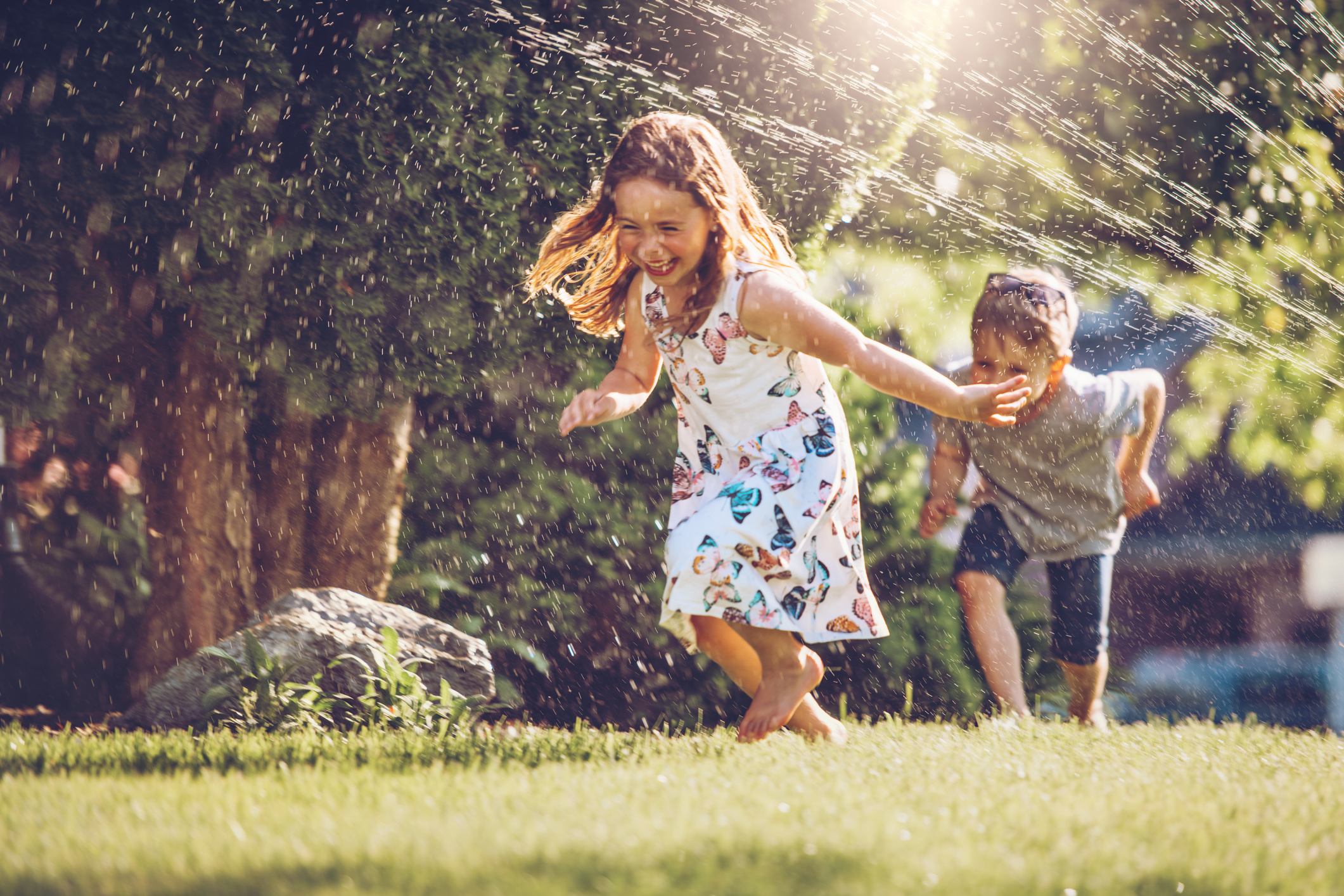Happy kids playing with garden sprinkler Happy kids playing with garden sprinkler