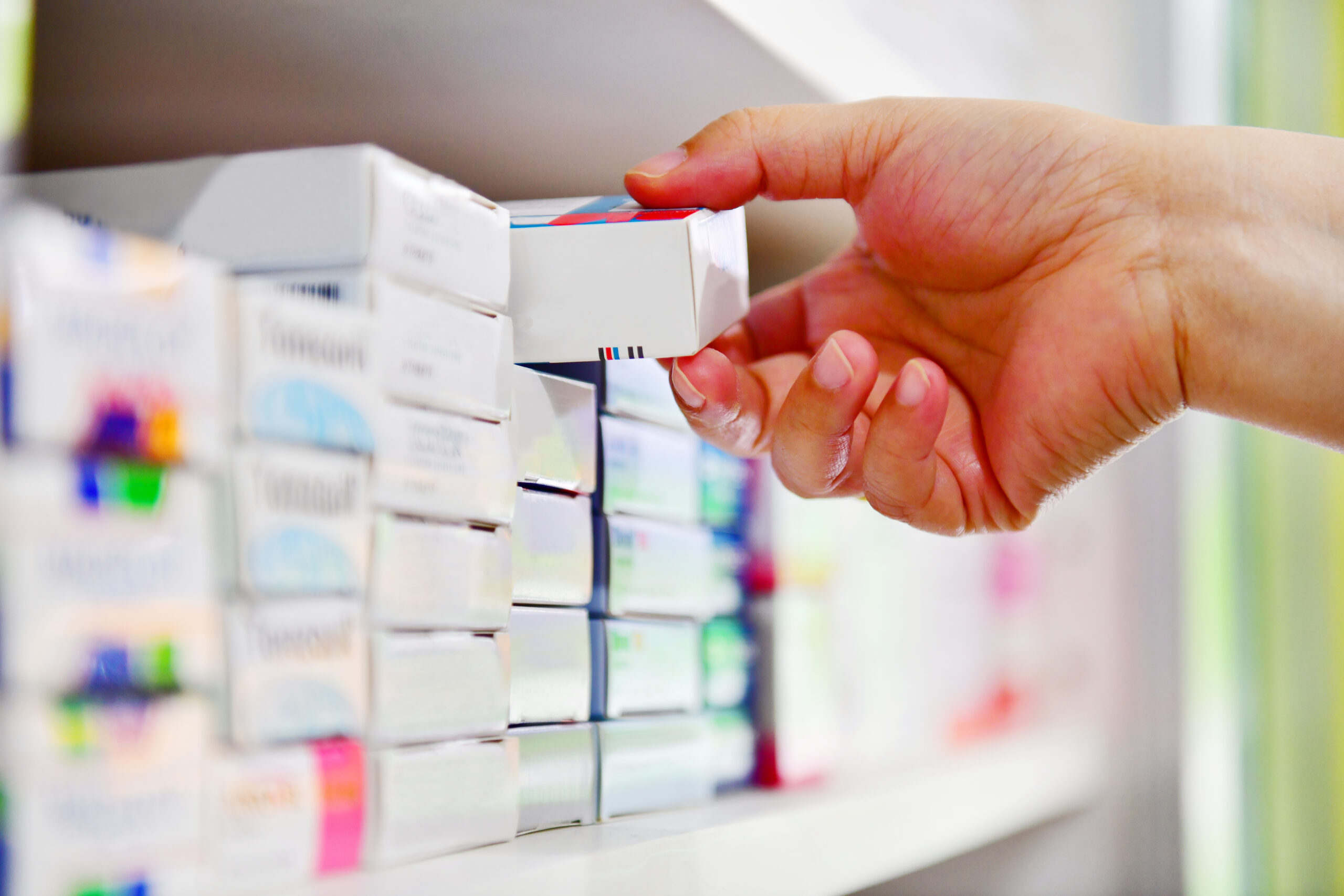 Hand holding medicine box in pharmacy drugstore. Hand holding medicine box in pharmacy drugstore.